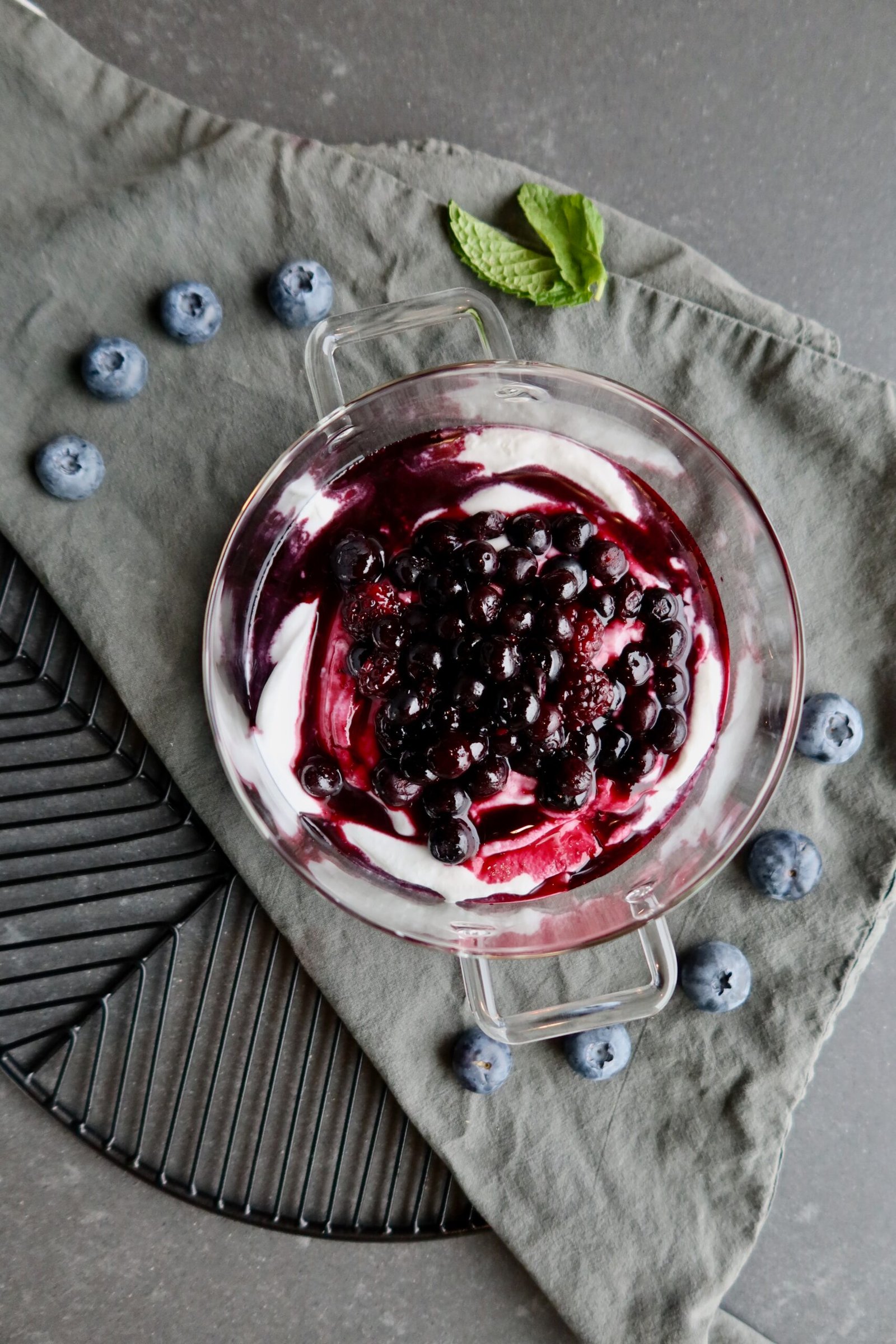 Coconut yogurt with warm blueberry compote swirled on top in a bowl