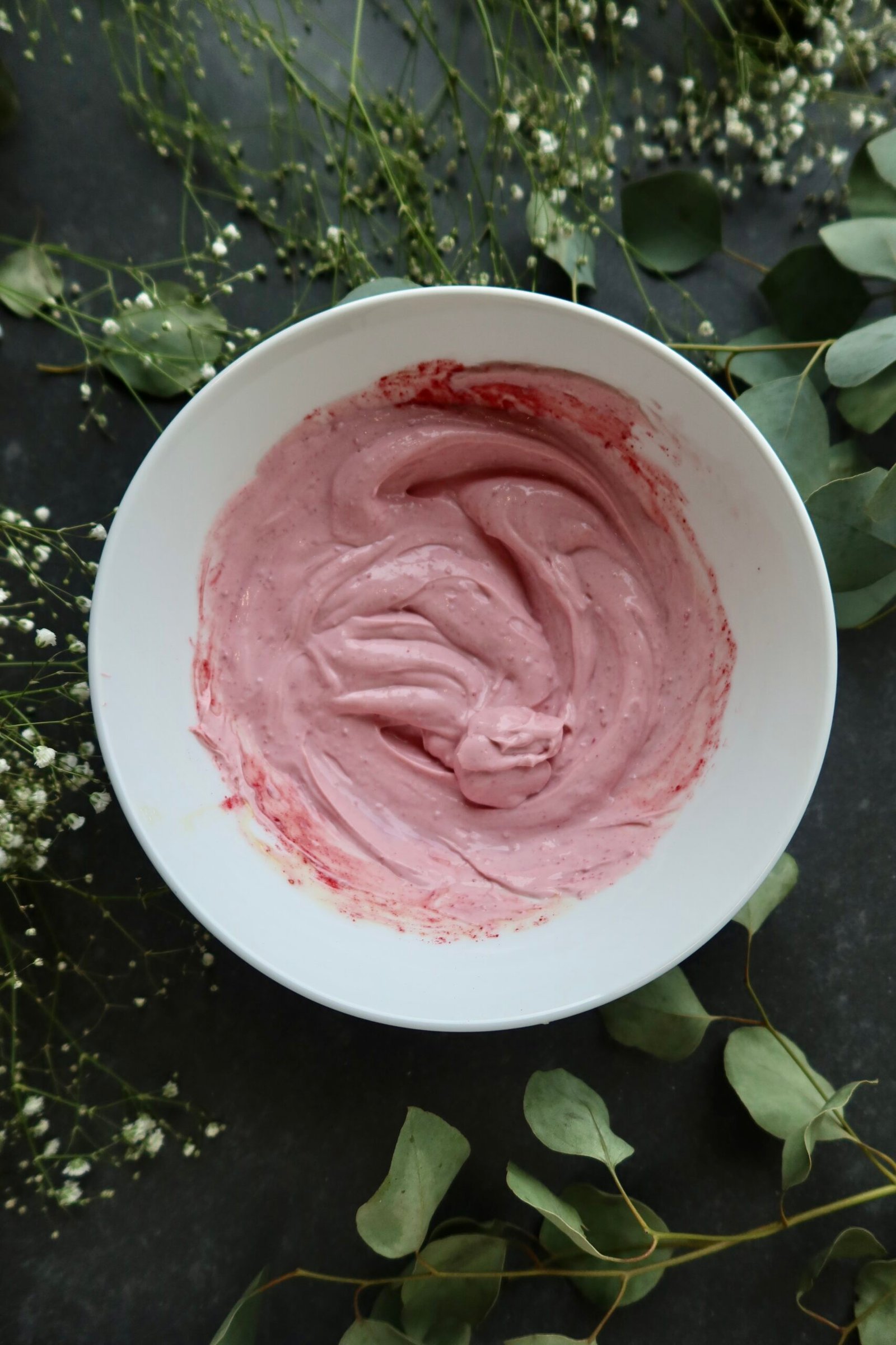 Pale pink raspberry whip being layered between high protein cottage cheese pancakes