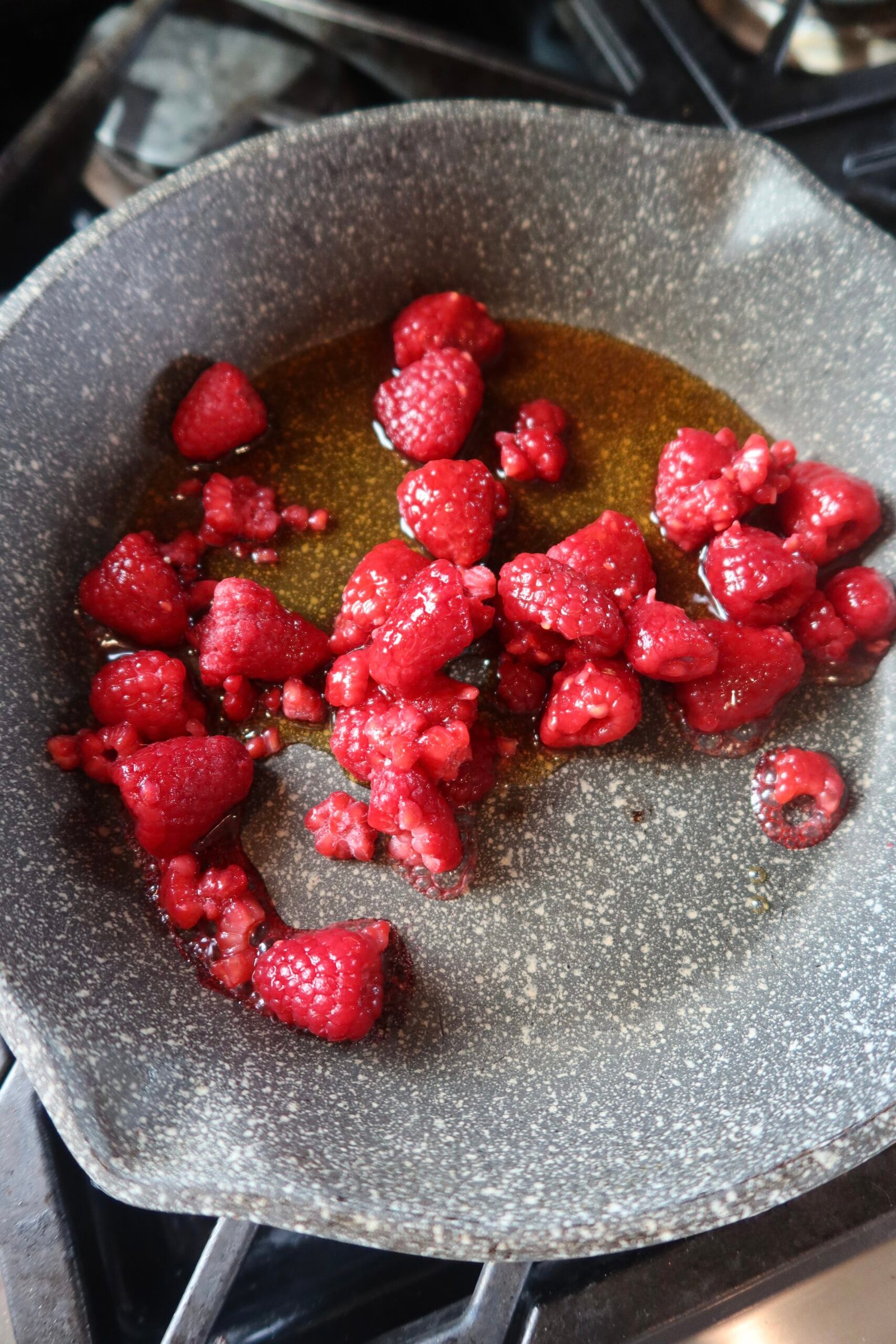Warm berry compote being spooned over high protein cottage cheese pancakes