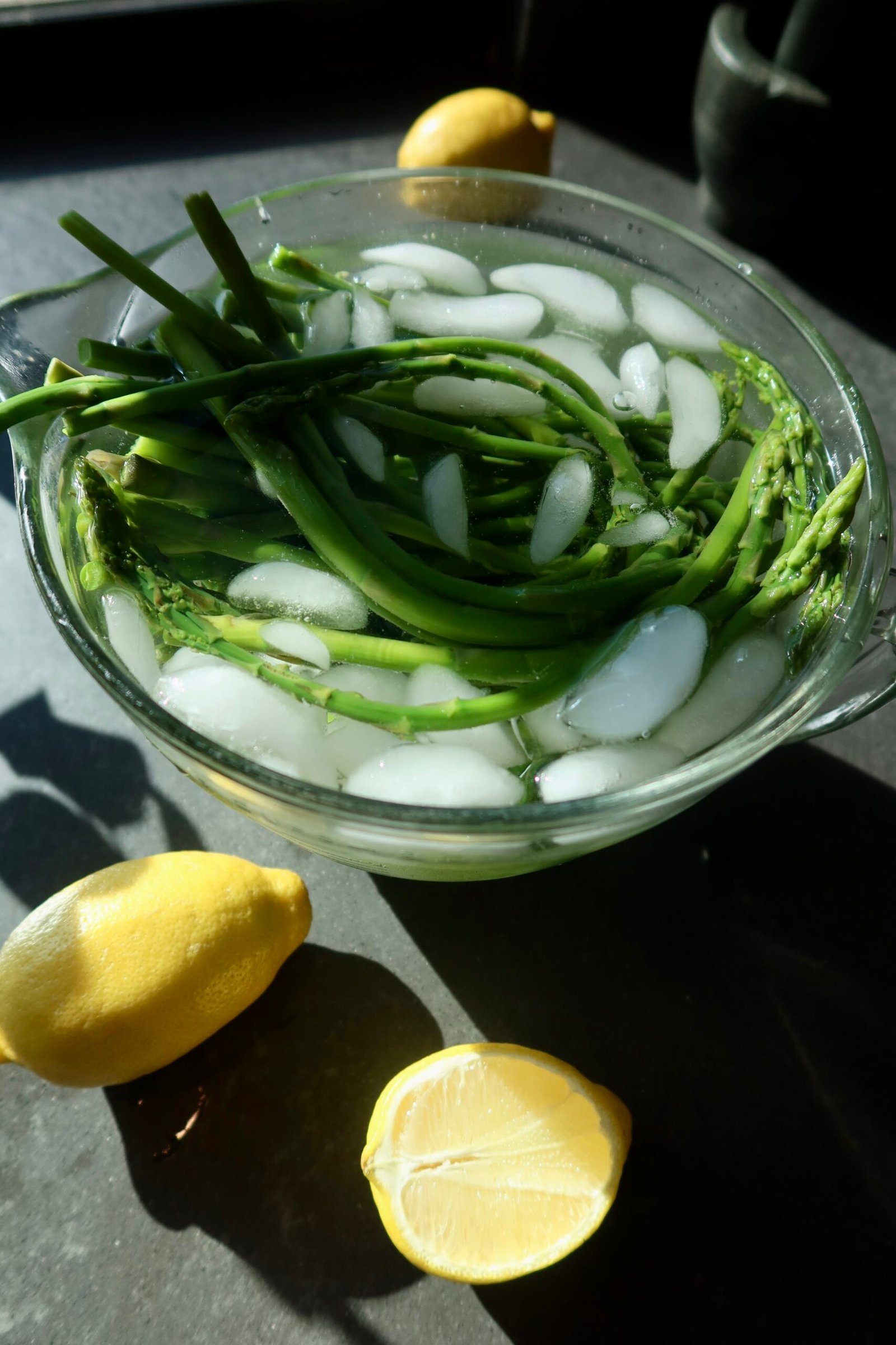 Bright green blanched asparagus in ice bath for spring asparagus garden plate