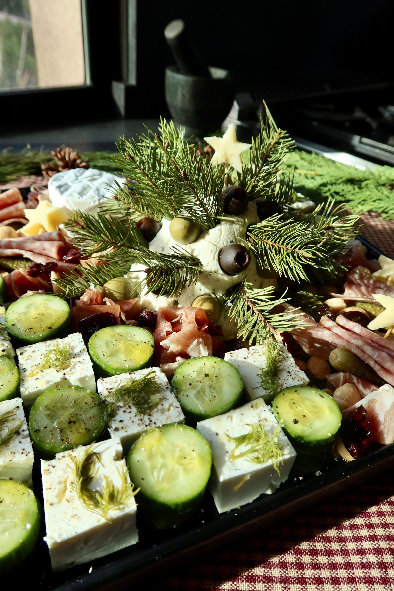 Feta cheese and cucumber rounds arranged in alternating checkerboard pattern for Christmas charcuterie board
