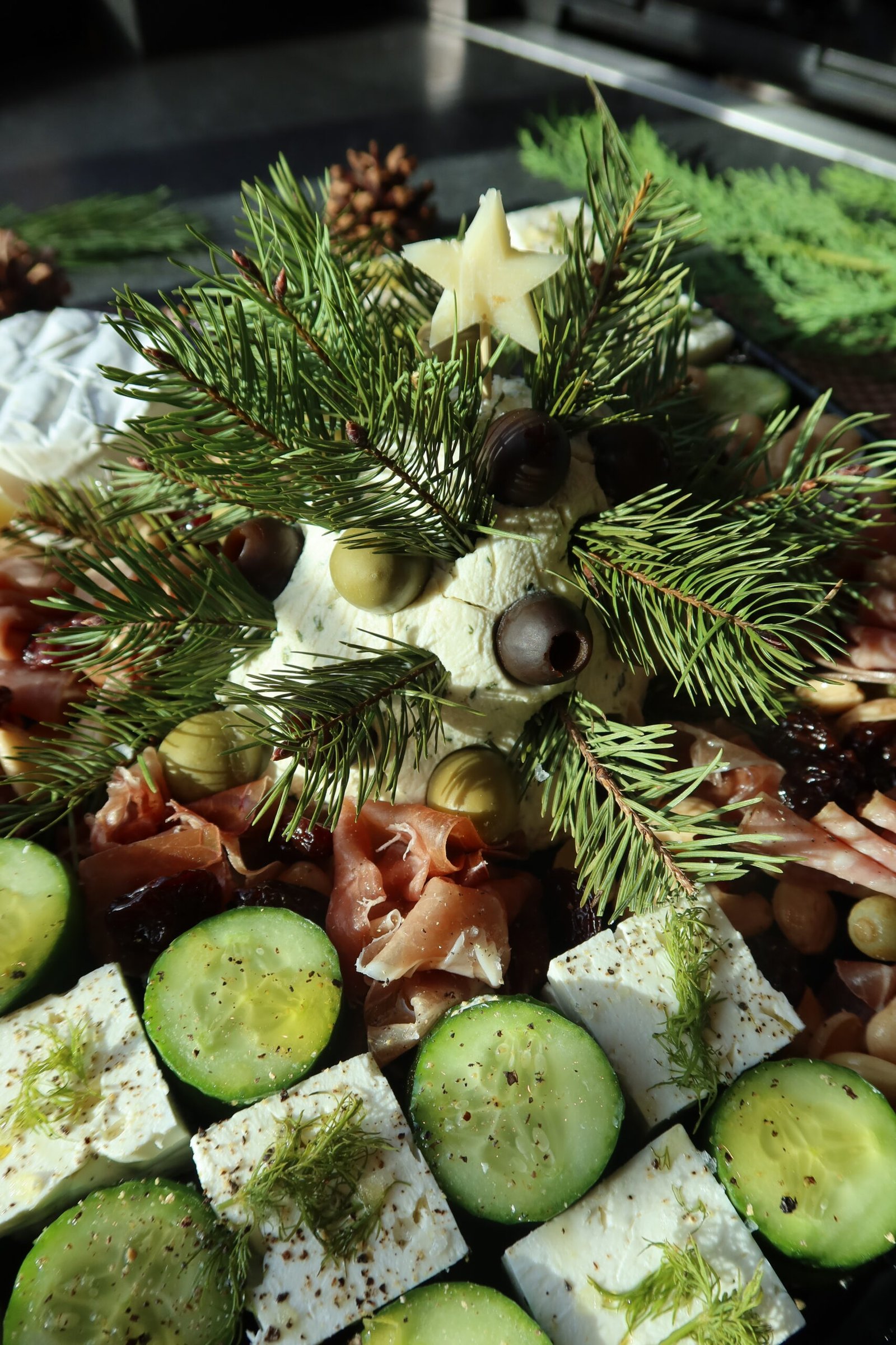 Boursin cheese Christmas tree decorated with green and black olives and fresh rosemary sprigs