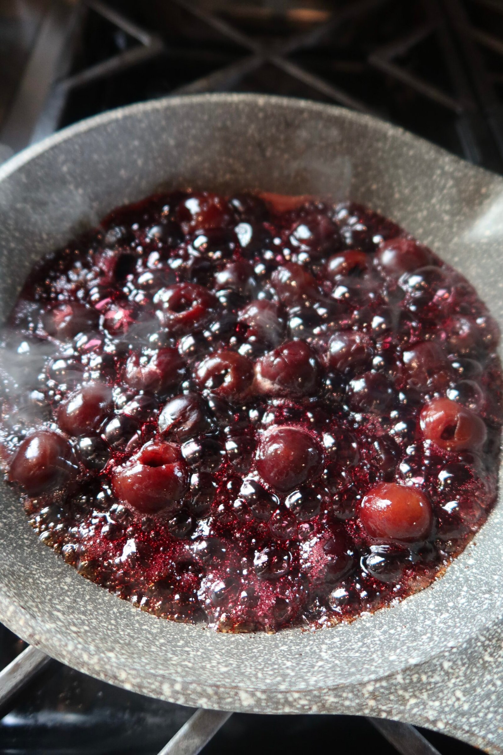 Warm cherry compote simmering in a pan for high protein almond cherry crepes
