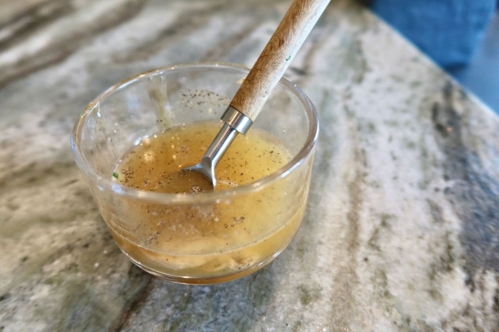 Citrus honey vinaigrette with fresh lemon orange Dijon and chives being whisked for spring salad