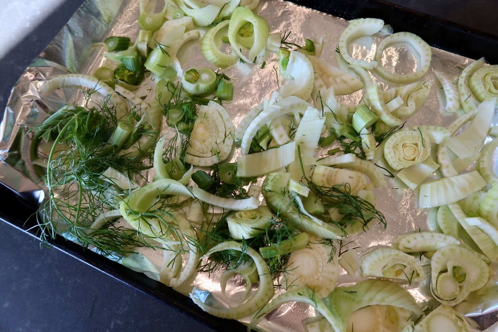 Golden roasted fennel with caramelized edges on a baking sheet for bright spring salad