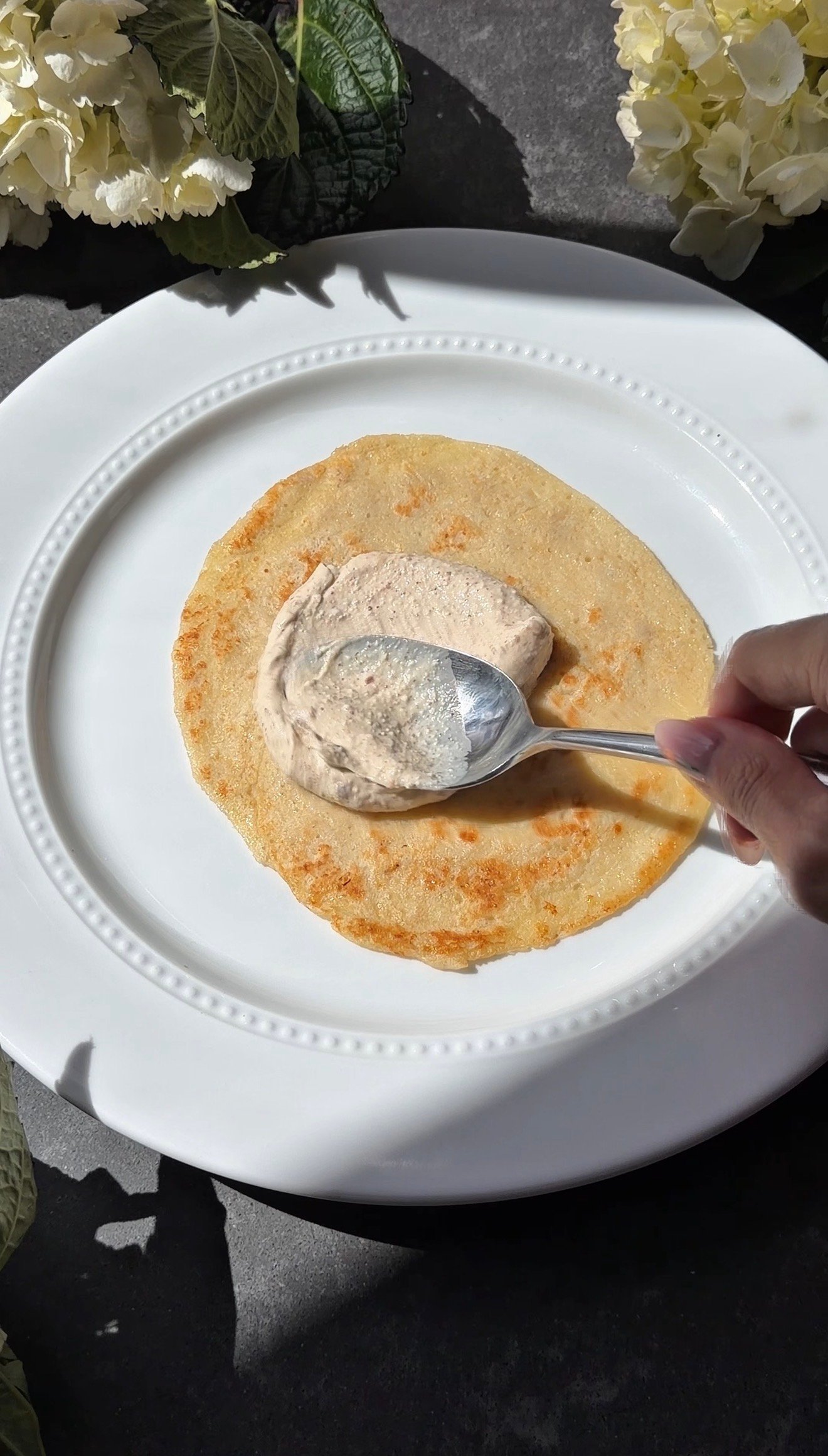 High protein almond croissant crepe stack layered with almond cream and topped with sliced almonds and powdered sugar