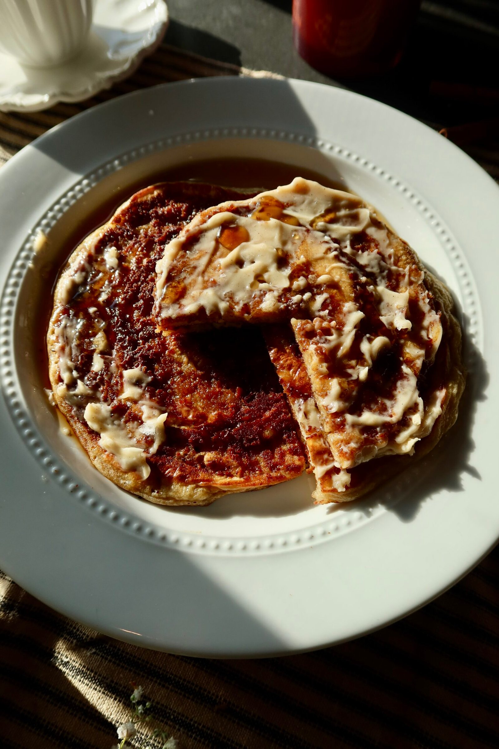 Stack of fluffy cottage cheese cinnamon roll pancakes with a caramelized maple-cinnamon swirl