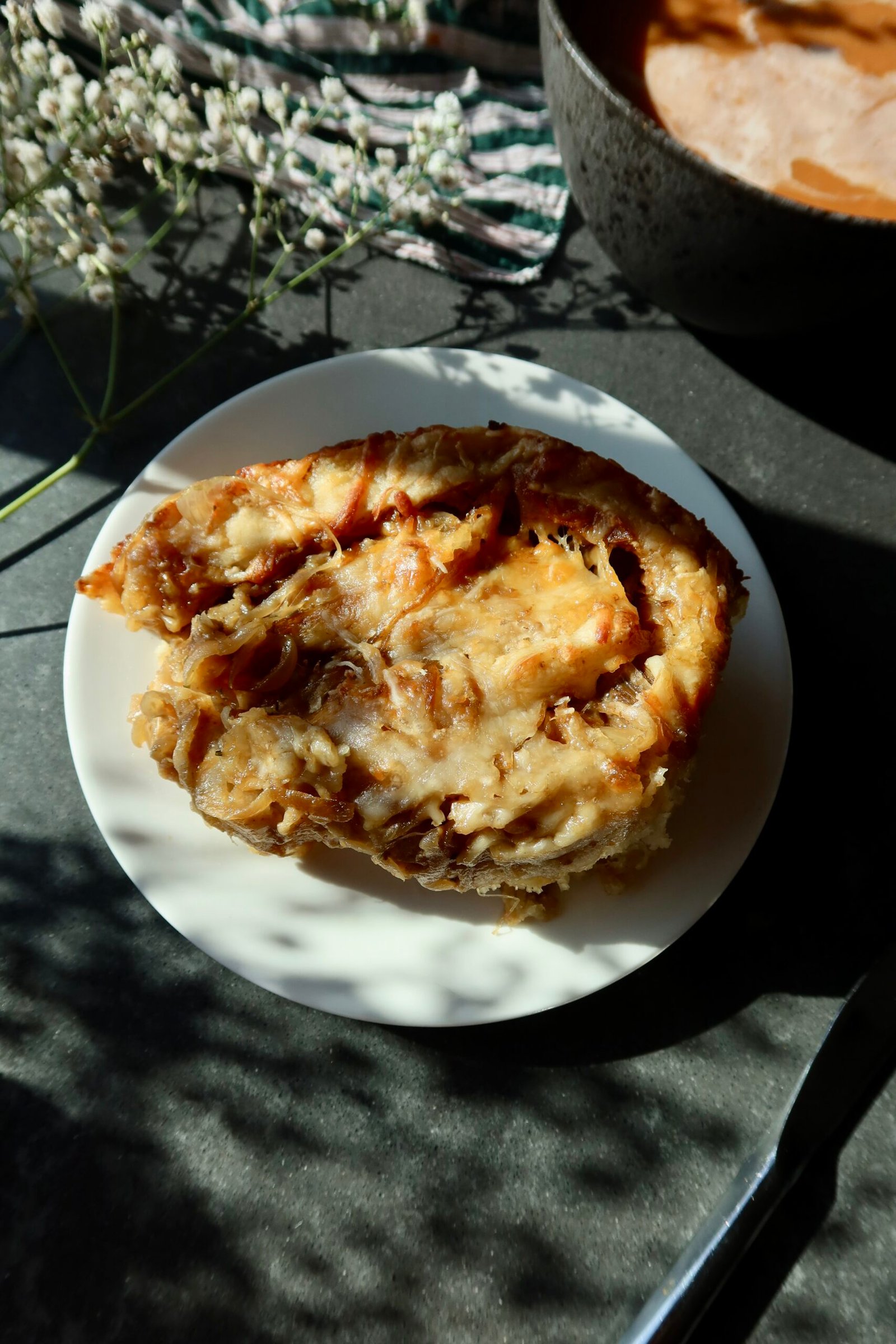 French onion soup rolls in a baking dish with melted Gruyère, caramelized onions and fresh thyme