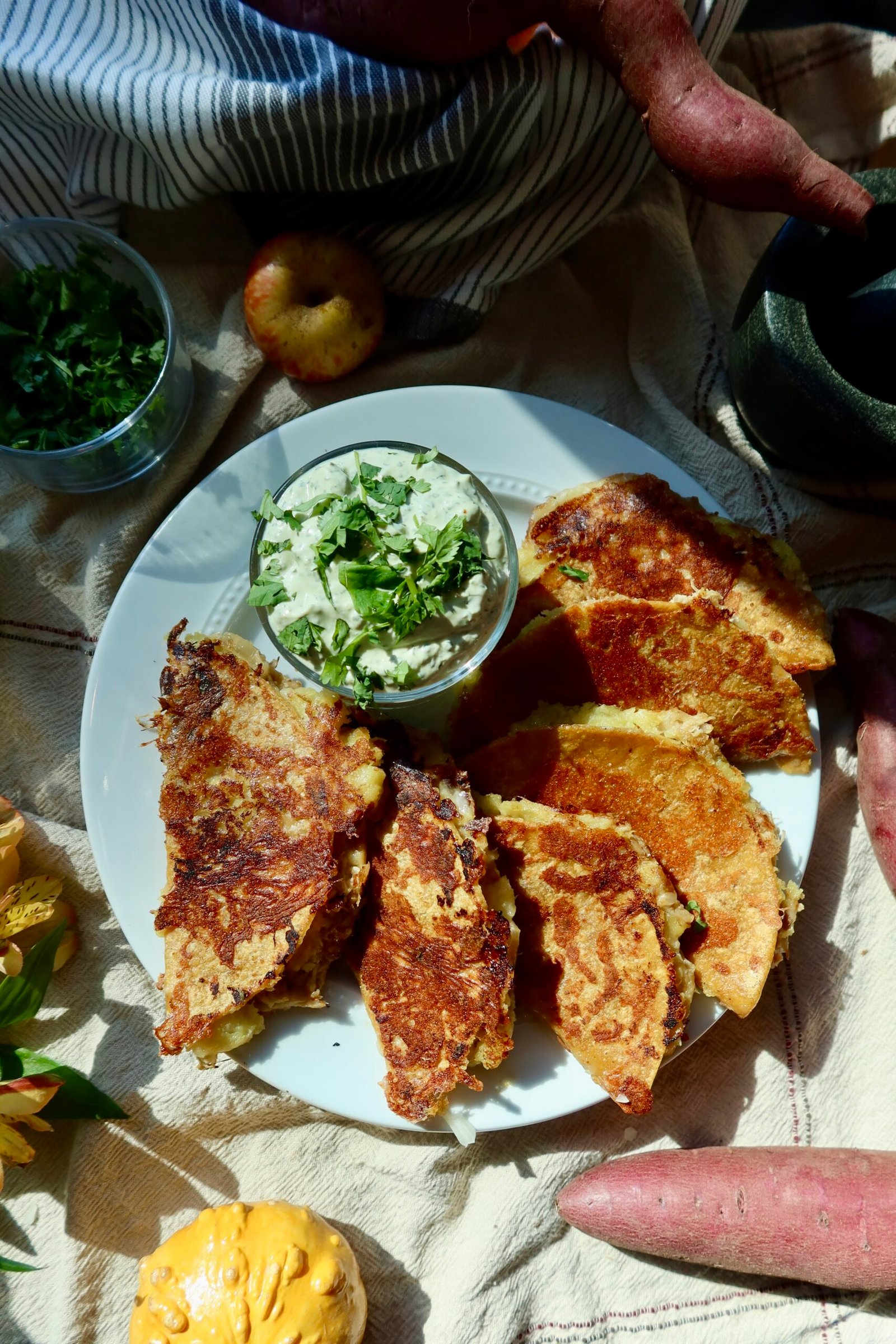 Crispy apple cider chicken tacos with smashed sweet potatoes, mozzarella, and avocado cilantro crema