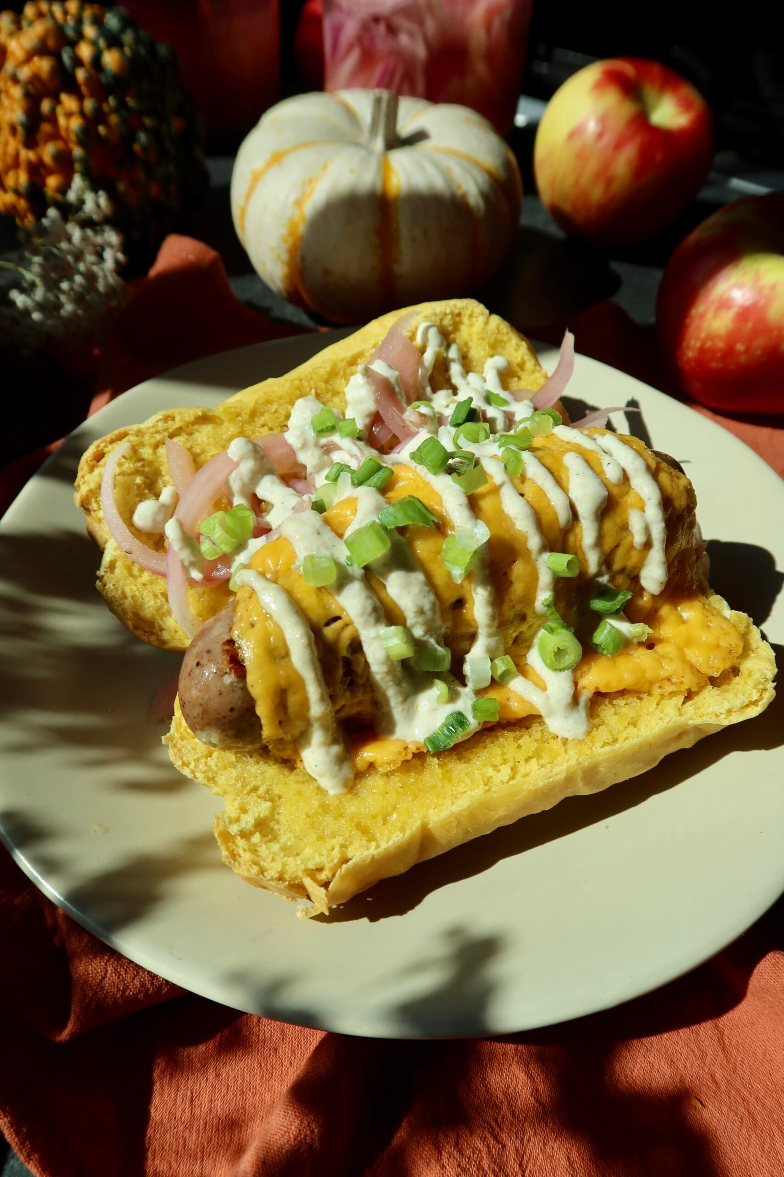 Fall New England hot dogs with pumpkin sourdough buns, chicken apple sausage, apple butter aioli, and pickled onions